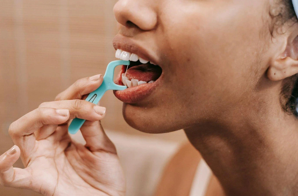 Patient flossing around braces to maintain healthy gums